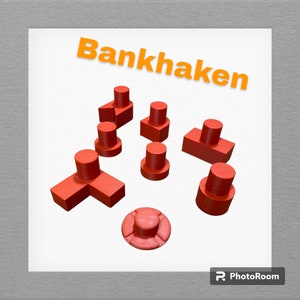 Op de afbeelding: Een set van negen rode plastic bouwstenen in verschillende vormen, waaronder een T-vorm, een vierkant en een cirkel. De blokken zijn gerangschikt op een wit oppervlak. Het woord "Bankhaken" staat in oranje letters bovenaan de afbeelding.