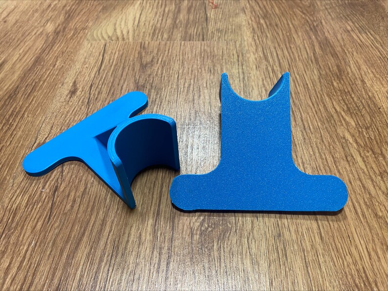 May include: Two blue plastic pieces that can be assembled to create a stand for a phone or tablet.