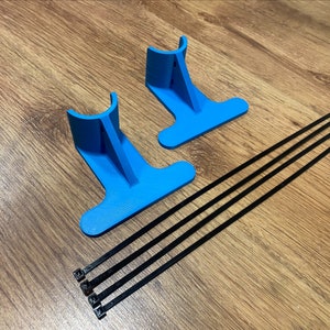 May include: Two blue plastic stands with a curved top and a flat base. Four black cable ties are included.