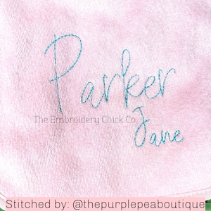 Puede incluir: Tela rosa con el nombre "Parker Jane" bordado en hilo turquesa. El texto "The Embroidery Chick Co." también está bordado debajo del nombre.