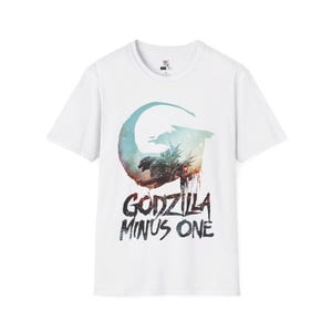 May include: White t-shirt with a graphic print of Godzilla in a galaxy-like background. The text "Godzilla Minus One" is printed below the graphic.