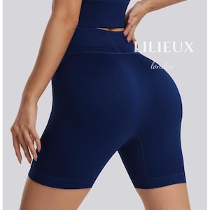 May include: A navy blue seamless ribbed biker shorts with a high waist and a wide waistband. The shorts are made of a stretchy, comfortable fabric and are perfect for working out or lounging around the house.
