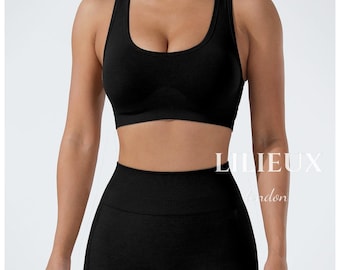 Completo composto da reggiseno sportivo senza cuciture e pantaloncini a vita alta, con scollo a U e spalline incrociate sulla schiena.