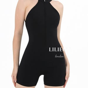 May include: Black sleeveless jumpsuit with a zipper up the front and a high neckline. The jumpsuit has a  "LILIE LONDON" logo on the front.