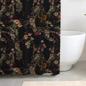 May include: A black shower curtain featuring a repeating botanical pattern of dark tree branches, small red cherries, light pink blossoms, brown roses, and tiny mushrooms. The fabric hangs from a silver rod with metal rings at the top edge.