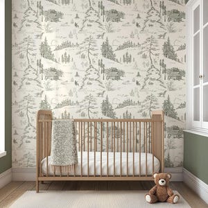 May include: A nursery scene featuring a wooden crib with a white mattress and a soft, light-colored blanket. The wall is adorned with wallpaper depicting a forest scene in shades of gray and white. A brown teddy bear sits on the floor.