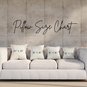 May include: A white tufted sofa with four pillows of varying sizes: 20" x 20", 18" x 18", 16" x 16", and 14" x 14". The text "Pillow Size Chart" is above the pillows. The background is a concrete wall.