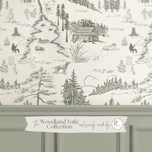 May include: Off-white wallpaper featuring a woodland toile design with illustrations of cabins, animals, and people fishing. The text "The Woodland Toile Collection" is displayed on the bottom. The design is in shades of gray and white.