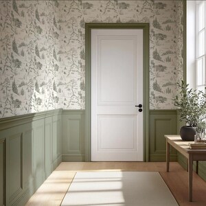 May include: A room with a white door, green trim, and wallpaper featuring a forest scene. A wooden table holds a plant and books. The room has a window and a light-colored rug.