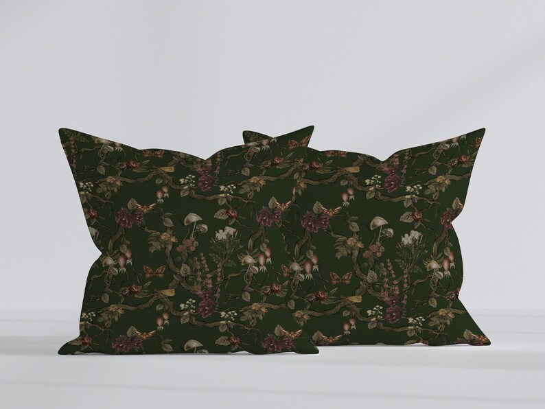 May include: Two decorative pillows with a dark green floral pattern. The pattern includes flowers, mushrooms, and butterflies in shades of brown, red, and white. The pillows are rectangular with a unique, scalloped edge.