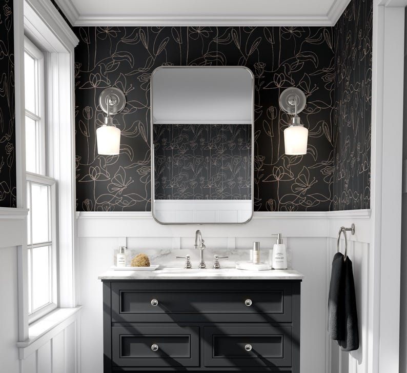 Puede incluir: Un papel tapiz floral blanco y negro con un contorno dorado. El papel tapiz est&aacute; en un ba&ntilde;o con un tocador negro y un espejo sobre el lavabo.
