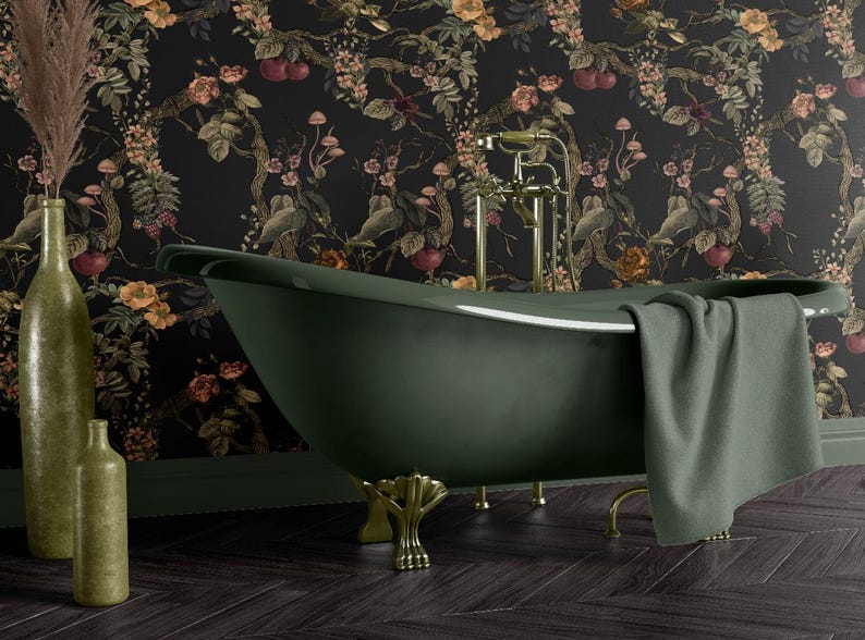 May include: An olive green clawfoot bathtub with gold fixtures and a gray towel. The bathroom features a dark floral wallpaper and two olive green decorative bottles. The floor is dark wood.