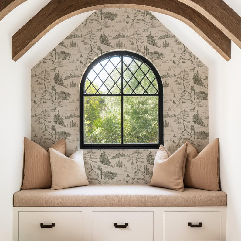 May include: A cozy window seat with a black arched window and a scenic wallpaper. The seat features beige cushions and pillows, with white storage drawers below. Wooden beams frame the window, creating a warm and inviting space.