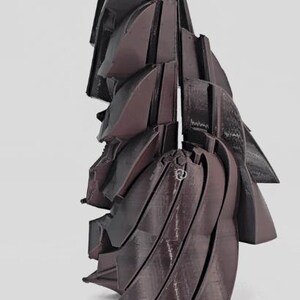 Pode incluir: Uma escultura abstrata marrom escuro com um design geom&eacute;trico em camadas. A obra de arte apresenta m&uacute;ltiplas formas curvas e angulares, criando uma apar&ecirc;ncia din&acirc;mica e texturizada. A pe&ccedil;a est&aacute; sobre um fundo branco liso.