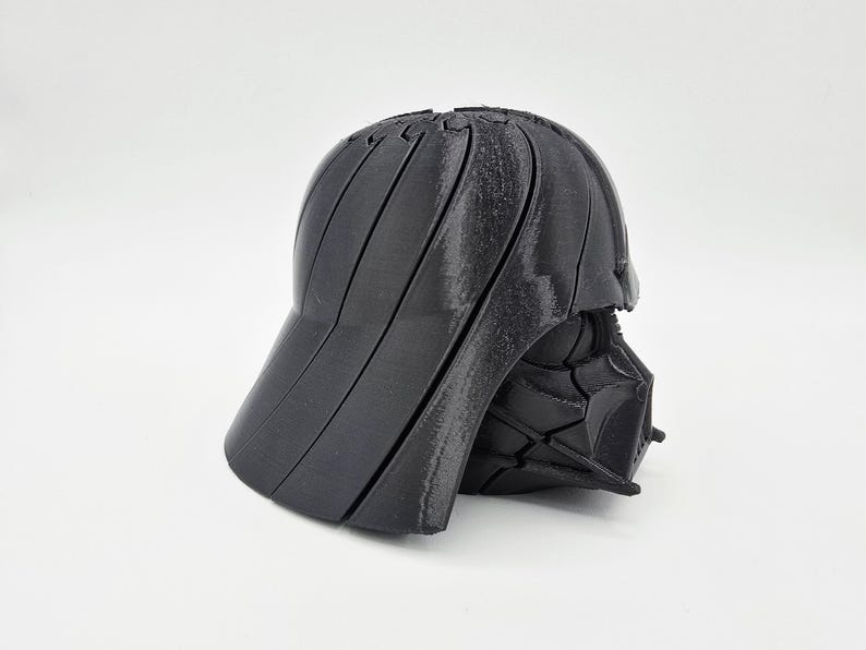 Pode incluir: Um bon&eacute; de beisebol preto, impresso em 3D, com um design segmentado &uacute;nico. O bon&eacute; apresenta uma aba curva e uma coroa estruturada, mostrando uma est&eacute;tica geom&eacute;trica moderna. O bon&eacute; &eacute; feito de um material preto fosco.
