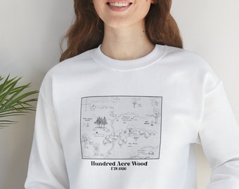 Op de afbeelding: Witte trui met een zwart-witte illustratie van een kaart van het Honderd Acre Bos uit Winnie de Poeh.