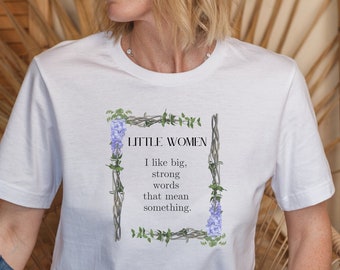 Può includere: Maglietta bianca con un design floreale e il testo "LITTLE WOMEN Mi piacciono le parole grandi, forti che significano qualcosa."