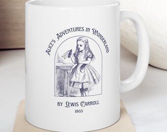 May include: White ceramic mug with a blue illustration of Alice from Alice's Adventures in Wonderland holding a bottle. The text "Alice's Adventures in Wonderland" is printed in a blue circle around the illustration. The text "By Lewis Carroll 1865" is printed below the illustration.
