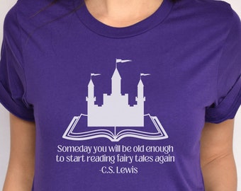 May include: Purple t-shirt with a white graphic of a castle on an open book. The text reads "Someday you will be old enough to start reading fairy tales again -C.S. Lewis"