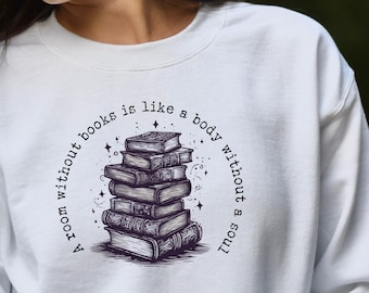 May include: White sweatshirt with a graphic of a stack of books and the text "A room without books is like a body without a soul."