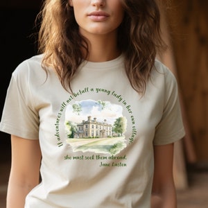 May include: Beige t-shirt featuring a watercolor illustration of a stately home within a circular frame. The text reads, "If adventures will not befall a young lady in her own village, she must seek them abroad. Jane Austen."