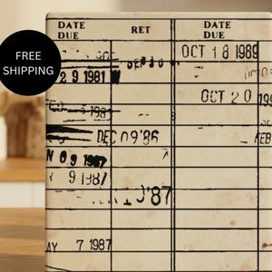 May include: A rectangular off-white library checkout card with black grid lines and columns labeled DATE DUE and RET. The card features various stamped dates in black ink, including OCT 18 1989 and OCT 20 1999, with some text crossed out by black ink marks.