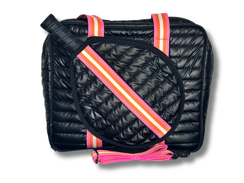 Puede incluir: Bolso tote acolchado negro con correas a rayas rosa y naranja. El bolso tiene una pala acolchada a juego en el interior.