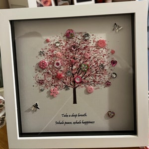 Peut inclure: Une image encadrée blanche avec un arbre à boutons rose et blanc avec la citation "Prenez une grande inspiration. Inspirez la paix, expirez le bonheur".