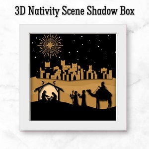 May include: A 3D shadow box nativity scene with a star, a stable, three wise men, a camel, and a city skyline in the background. The scene is set against a black background with gold accents.