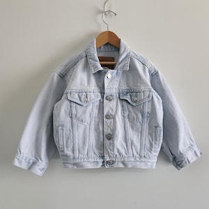 May include: A set of three ceramic mugs with a speckled, matte finish. The mugs are in shades of cream, light gray, and dark gray. Each mug has a simple, minimalist design, perfect for coffee or tea.