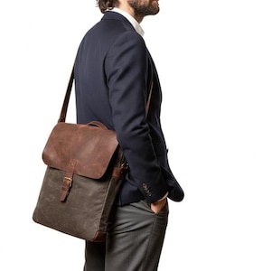 May include: A brown and olive green messenger bag with a leather flap and a buckle closure. The bag is worn over the shoulder and has a long adjustable strap. The bag is made of a durable material and is suitable for carrying books, a laptop, or other items.