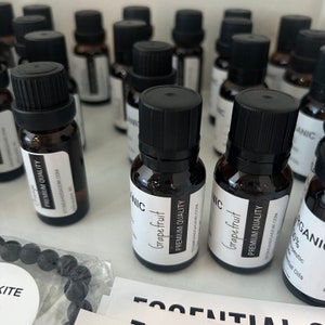 May include: A close-up of several small brown glass bottles with black caps. The bottles are labeled with white text that reads "Organic Grapefruit Premium Quality".
