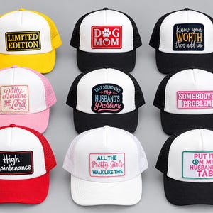 May include: Nine trucker hats with white foam fronts and mesh backs, featuring various rectangular patches with text including Limited Edition, Dog Mom, Know Your Worth, Daily Routine The Lord, That Sound Like My Husband's Problem, Somebody's Problem, High Maintenance, All The Pretty Girls Walk Like This, and Put It On My Husband's Tab.