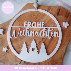 May include: White Christmas decoration with the German words "Frohe Weihnachten" in a circular design. The design features stylized trees and stars, displayed on a wooden surface. The text "GLOWVYBE" is in a pink circle.
