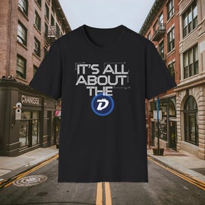 May include: Black t-shirt with white text that reads "It's All About The D" with a blue and white stylized letter D in a circle.