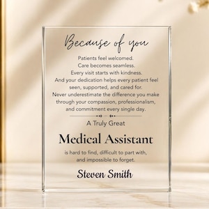 May include: A rectangular clear acrylic plaque featuring black printed text that reads: Because of you, Patients feel welcomed. Care becomes seamless. Every visit starts with kindness. A Truly Great Medical Assistant is hard to find, Steven Smith.