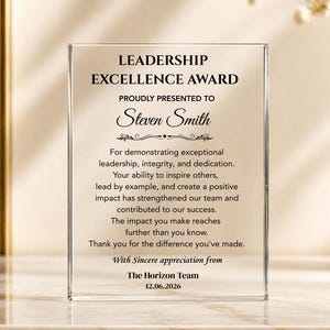 May include: A rectangular clear acrylic award plaque featuring black printed text that reads LEADERSHIP EXCELLENCE AWARD, PROUDLY PRESENTED TO Steven Smith, followed by a message of appreciation from The Horizon Team dated 12.06.2026.