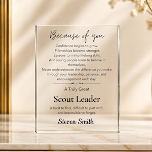 May include: A rectangular clear acrylic plaque featuring black printed text that reads: Because of you, Confidence begins to grow. Friendships become stronger. Lessons turn into lifelong skills. And young people learn to believe in themselves. Never underestimate the difference you make through your leadership, patience, and encouragement each day. A Truly Great Scout Leader is hard to find, difficult to part with, and impossible to forget. Steven Smith.