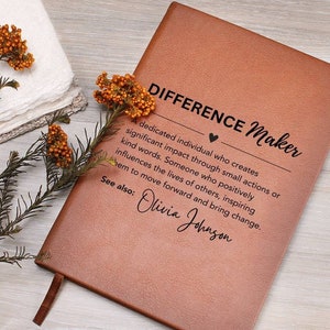 May include: A brown leather journal with the text "DIFFERENCE Maker" and a definition of the term. The definition includes the text "See also: Olivia Johnson".