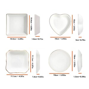 May include: Four white ceramic dishes with gold trim in various shapes: square, heart, and round. Measurements are provided in inches and centimeters. The square dishes are 4.09 inches (10.4 cm) wide. The heart and round dishes are 3.93 inches (10 cm) wide.