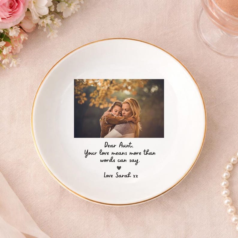 May include: A white ceramic trinket dish with a gold rim. The dish features a photograph of a woman and child, with the text "Dear Aunt, Your love means more than words can say. Love Sarah xx."