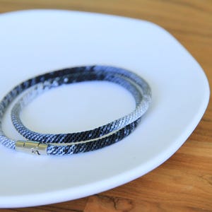 Könnte beinhalten: Eine weiße Keramik-Tasse mit schwarzem Henkel und dem Text "But First, Coffee" in schwarzer, fetter Schrift. Die Tasse steht auf einer weißen Oberfläche. Die Tasse ist 10 cm hoch.