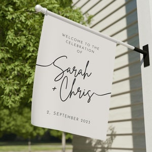 May include: White wedding welcome sign with black text. The sign reads "Welcome to the celebration of Sarah + Chris, 2 September 2023".
