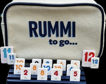 Mini Rummi Kub travel set . Canvas bag, 106 Rummi kub game tiles and 4 wooden racks all in our sturdy and chic Rummi to go bag.