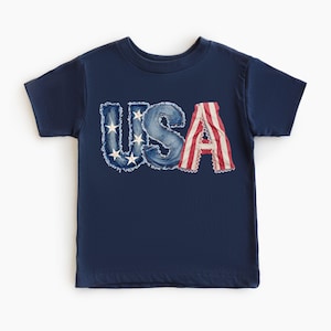 A navy blue t-shirt with the word "USA" printed on it in stylized lettering.