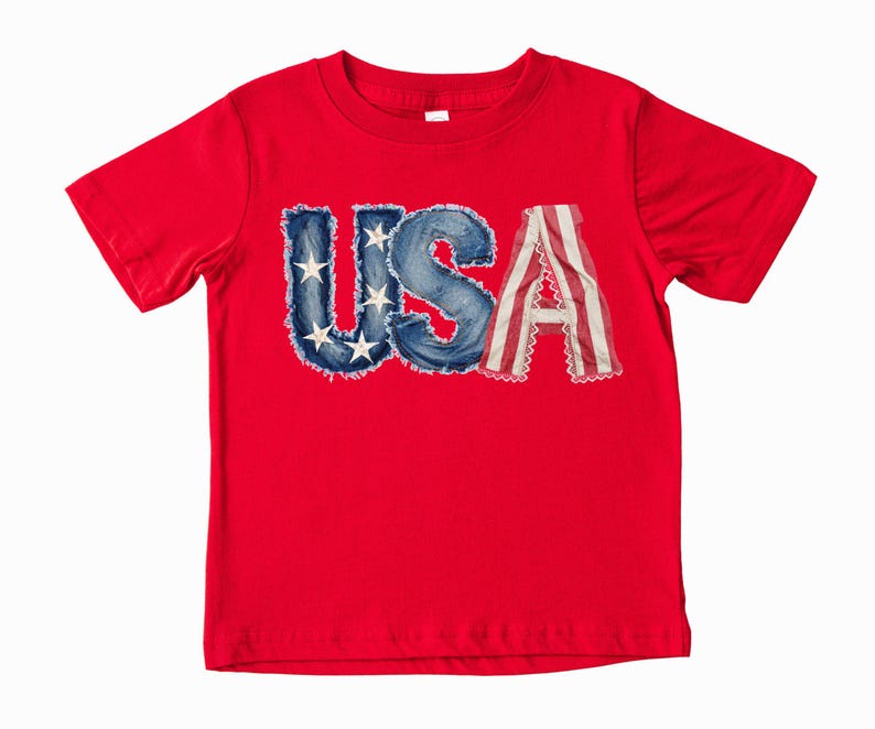 A red t-shirt with the word "USA" printed on it, featuring the letters in a stylized, distressed font.