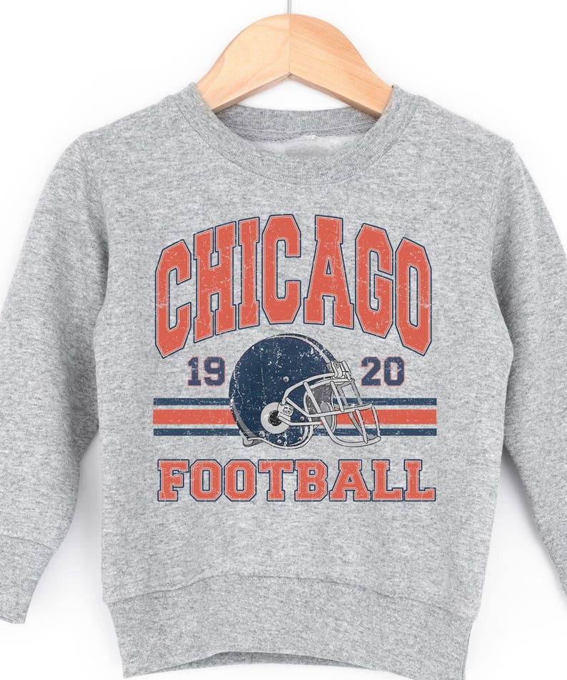 A grey sweatshirt with a graphic design featuring a football helmet and the text "CHICAGO FOOTBALL" printed on it.