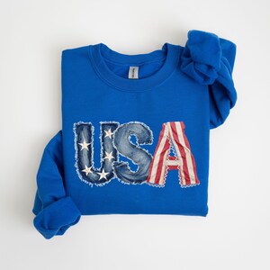 A blue sweatshirt with the word "USA" printed on it, featuring the American flag design.