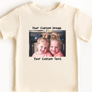 May include: A white t-shirt with a photo of two girls smiling and the text "Your Custom Image" and "Your Custom Text" printed on it.