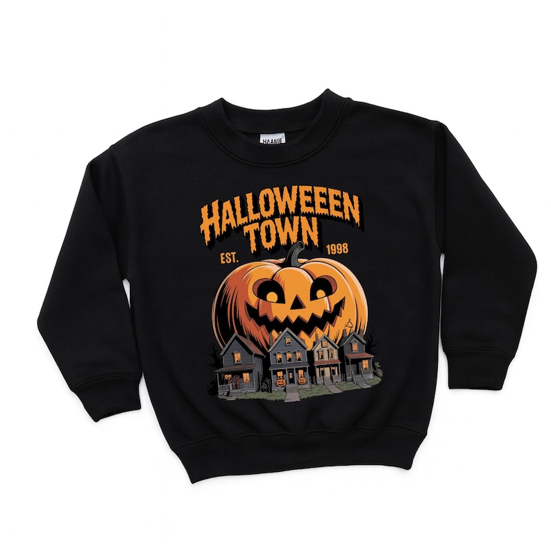 A black sweatshirt with a Halloween-themed graphic design. The design features a large jack-o-lantern and a house, with the text "Halloween Town" and "Est. 1998" printed on the front.